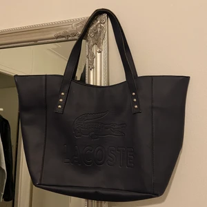 Lacoste stor väska  - mörkblå väska från lacoste, jag älskar den här väskan men jag behöver pengarna, i nyskick och stora💕