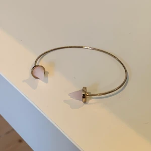 Armband - Snyggt Armband i guld med ljusrosa nitar