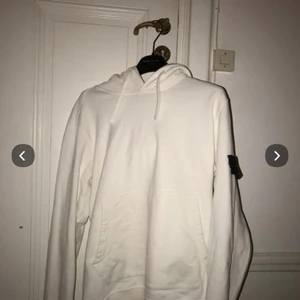 Vit Stone island hoodie  - En fin Stone island hoodie utan fläckar köpt på Nk i Stockholm och skicket är 8/10 i storlek M                                   (HJÄLPER EN VÄN)