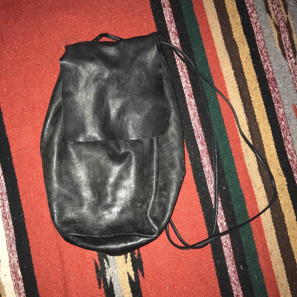 I bought this preloved on Depop. Black with excellent patina, natural fading and markings on leather. Drawstring closure which can be adjusted. Inner pocket and unlined suede interior. Buttery, soft leather. Some of the rivet linings are coming off, but can be easily fixed with glue (have a professional do it!) Smoke and pet free storage space. No other flaws to note. Will gladly take more pics.   Disclaimer: Please expect some general wear in all secondhand pre-owned items. . Väskor.
