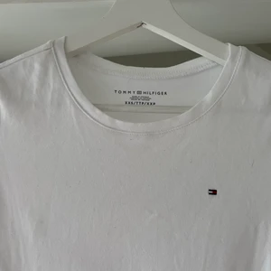 Vit tshirt från Tommy Hilfiger - Vit t-shirt från Tommy Hilfiger i skön kvalitet. Fint skick. Storlek XS. Ord orus 399 kr. Endast 80 kr. Finns i Vällingby.