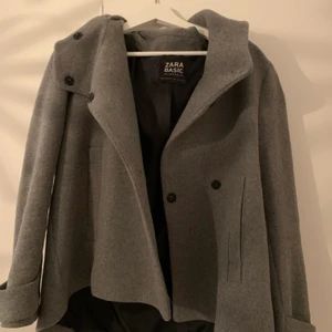 Kort kappa från Zara, storlek S - En så fin grå kappa från zara, i en kortare modell. Den har dessvärre tappat en knapp men är annars i fint skick, den går såklart forfarande att stänga. Den är i storlek S, men skulle säga att den passar XS-M beroende på hur man vill att den ska sitta. 