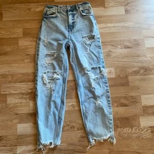 Mom jeans - Mom jeans med slitningar. Plagget anger stl 34, jag skulle snarare säga stl 32. Aldrig använda.