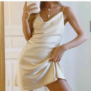 M-KAE satinklänning - Beige satinklänning från M-KAE (danskt märke). Köpt för ca 700 kr översatt från danska kronor. XS - vanlig i storleken och har reglerbara band över axlarna. 