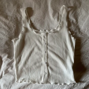 Ny vit stickad topp strl S/M - Helt ny vit söt stickad topp i storlek S/M. Kommer med extra knapp. Superskön ribbad/stickad. Frakt 26kr🥰