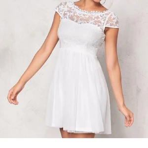 Vit klänning / studentklänning, Vila - Vit klänning i fint skick från Vila som passar perfekt till studenten. Den går till strax under knäna på mig som är 156cm kort :)