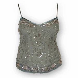 Spagetti Strap - Supersöt spaghetti strap top från Vera Moda, storlek M. I bra skick! Modellen använder vanligtvis storlek S-M och är 169cm. Shell: 100% nylon. Lining: 100% bomull. Längd (banden är justerbara) 61cm. Byst bredd 38cm. Spårbar frakt på 66kr är inräknad i priset.  