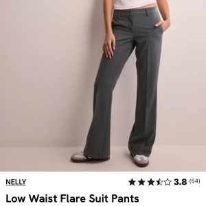 Kostymbyxor  - Helt oanvända gråa kostymbyxor, prislappen sitter kvar.  Modellen: Low waist flare suit pant