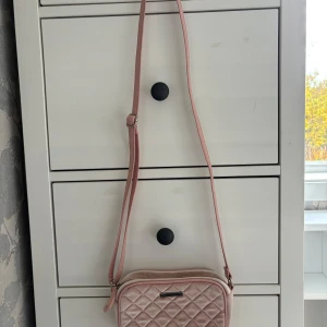 Guess väska  - Snygg Guess väska. Kommer tyvärr inte till användning längre. Tyvärr lite missfärgningar uppe vid dragkedjan och på baksidan av väskan (se bilder) syns dock bara i vissa ljus. Annars o bra skick. Skriv för fler bilder.