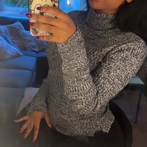 Gråmelerad polotröja - Säljer en supermysig gråmelerad polotröja som är perfekt för kyliga dagar. Den är stickad och har långa ärmar, vilket gör den både varm och stilren. Passar perfekt till både vardags och lite mer uppklädda tillfällen. 🖤Från Nelly