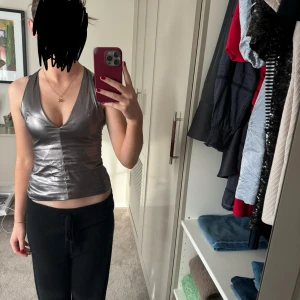Topp - En silvrig, halterneck festtopp från zara. Använd en gång och är i nyskick💕💕