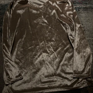 Beige sammetströja från Cantwo - Snygg beige tröja i mjukt sammetstyg Tröjan har långa ärmar och en rund halsringning. Perfekt för en stilren och bekväm look. Guld tryck 