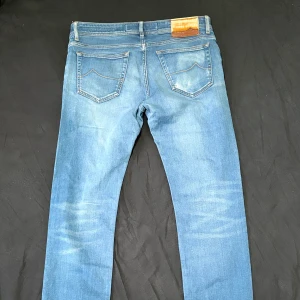 Jacob Cohen jeans - Snygga blå jeans från Jacob Cohen sitter slimfit har en liten defekt men syns inte då fickan täcker det storlek 34