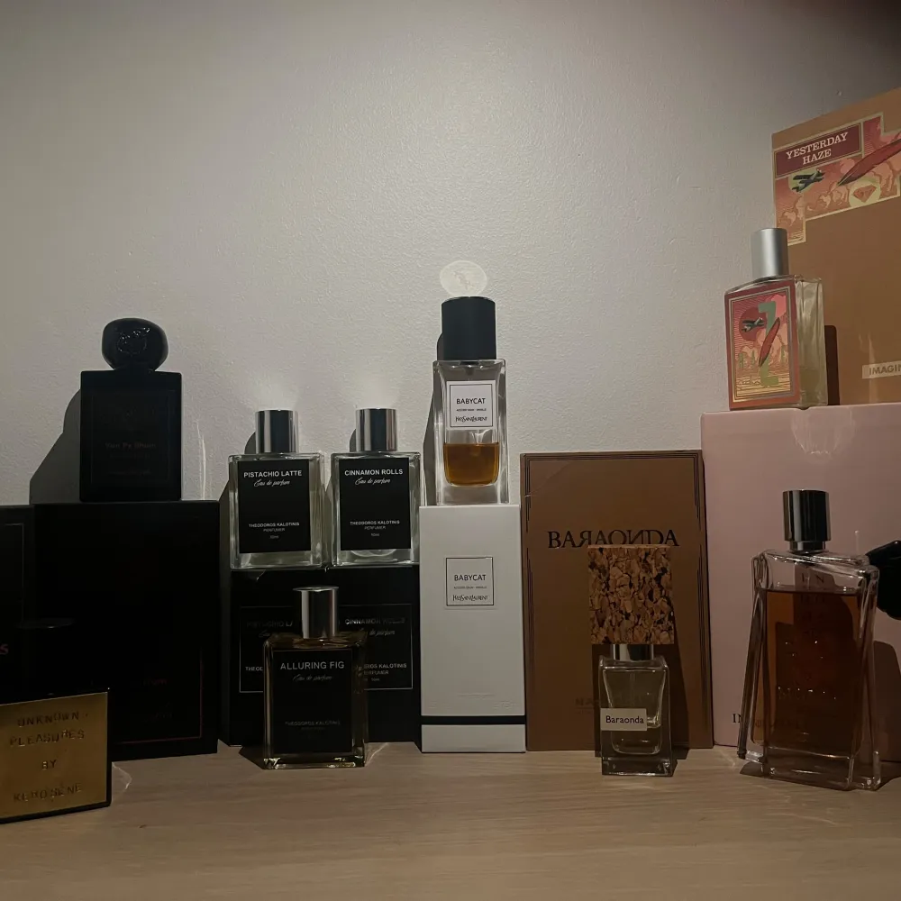 En samling av exklusiva parfymer från olika märken. Flaskorna varierar i design och färg, med både mörka och ljusa toner. Perfekt för den som vill ha en varierad doftgarderob.. Perfume.