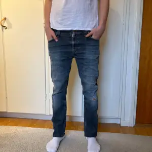 Asfeta Nudie jeans med riktigt schysst fade. Både slitningar och fade har kommit med tiden vilket ger en go karaktär. Storleken är 33/34, modellen på bilden 185 cm och väger 72 kg. Tveka inte på att höra av dig ifall du undrar något!
