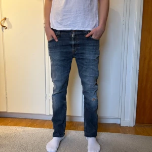 Nudie Jeans - Asfeta Nudie jeans med riktigt schysst fade. Både slitningar och fade har kommit med tiden vilket ger en go karaktär. Storleken är 33/34, modellen på bilden 185 cm och väger 72 kg. Tveka inte på att höra av dig ifall du undrar något!