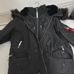 Svart parkajacka från Alpha Industries - XL Alpha industries jacka bra för när man åker skidor eller är ute länge. Många fickor för redskap. Om man bor i Uppsala går det att ändra priset.