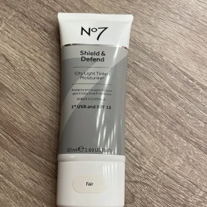 No7 Shield & Defend City Light Tinted Moisturiser - No7 Shield & Defend City Light Tinted Moisturiser i nyansen Fair. Denna tonade fuktighetskräm ger lätt täckning och skyddar huden med SPF 15. Perfekt för känslig hud och innehåller antioxidanter för att bekämpa miljömässiga stressfaktorer. Den är oöppnad och jag säljer pga att den bara låg och skräpade.