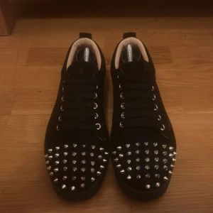 Svarta sneakers med nitar - Snygga svarta sneakers med silverfärgade nitar på tån och snörning. Perfekta för att ge en edgy touch till din outfit.