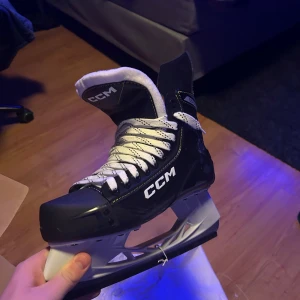 Svarta skridskor från CCM - Hej! Jag köpte ett par helt nya CCM skridskor, men när jag gick hem dom så passade dom inte tyvärr så jag gör ett försök att sälja dom här! Dom är i helt nytt skick och aldrig använda, bara testade. Skydden sitter kvar på och man får med lådan och allt precis som från butik. Storlek 44,5