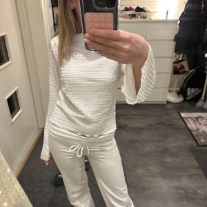 Vit långärmad tröja från 157 - Säljer en stilren vit långärmad tröja från 157. Tröjan har en texturerad yta och en bekväm passform. Perfekt för en avslappnad look.