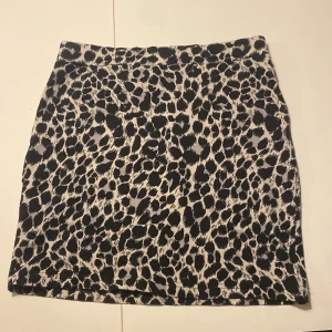 Leopardmönstrad kjol från Divided - Snygg leopardmönstrad kortkjol från Divided by H&M. Perfekt för att ge din outfit en trendig touch. Kjolen har en klassisk passform och är lätt att matcha med olika toppar.