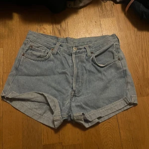 Blå jeansshorts - Snygga blå jeansshorts med klassisk femficksdesign och uppvikta ben. Perfekta för en avslappnad stil. De har en knapp och dragkedja framtill.