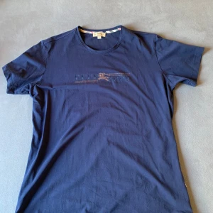 Mörkblå t-shirt från Burberry - Säljer en snygg mörkblå t-shirt från Burberry i storlek XL. Passar mer som L. 