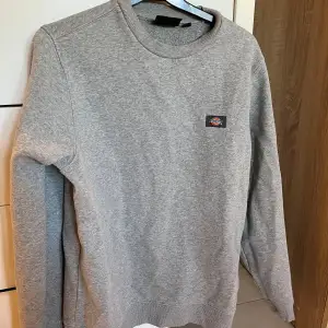 Säljer en bekväm grå sweatshirt från Dickies i storlek XS. Tröjan har en klassisk design med rund hals och ribbade muddar. Perfekt för både vardag och chill. Den är i begagnad men helt ok skick! 