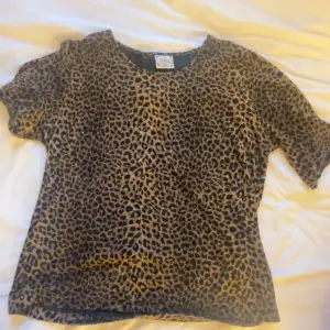 Säljer en snygg leopardmönstrad topp i mjukt material. Den har korta ärmar och en normal passform, perfekt för en cool och avslappnad stil. Passar både till vardags och fest!