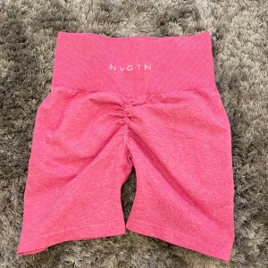 Rosa shorts från NVGTN - Säljer ett par snygga rosa shorts från NVGTN i storlek XS. De är högmidjade och har en scrunch-detalj bak som ger en fin passform. Perfekta för träning eller en avslappnad dag. Materialet är mjukt och stretchigt för bästa komfort.💕