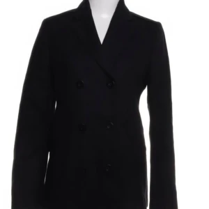 Svart kappa från Filippa K - Säljer en stilren svart kappa från Filippa K i storlek S. Den har en klassisk design med dubbelknäppning och långa ärmar. Perfekt för både höst och vinter, och funkar lika bra till vardags som till fest. Kappan är i bra skick och redo för en ny ägare!