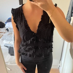 Topp - Med lite snörningar, västliknande stickad topp