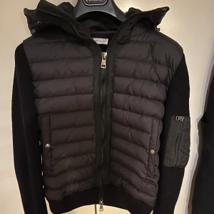 Svart Moncler cardigan - Hej säljer min moncler cardigan för den har blivit lite för liten och för att jag inte använder den så mycket. Jag har påsen och tagsen kvar men inget kvitto då jag fick den i present. Därför säljer jag den lite billigare än dem andra som har kvitton. Den är i ett väldigt bra skick.