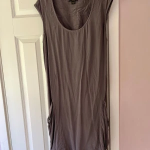 Brun klänning från Diesel - Säljer en stilren brun klänning från Diesel i storlek M. Klänningen har en enkel design med rund hals och ärmlös stil, perfekt för en avslappnad look.