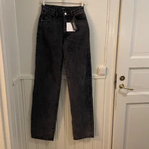 Svarta jeans från Boohoo - Snygga svarta jeans från Boohoo i en klassisk straight fit. De har en hög midja och är tillverkade i ett slitstarkt denimtyg. Perfekta för en stilren look. (!HELT OANVÄDA!)