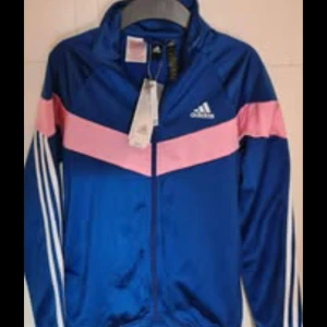 Ny Adidas träningsjacka storlek 152. - Helt ny Adidas zip träningsjacka.  Blå/rosa. Storlek 152.