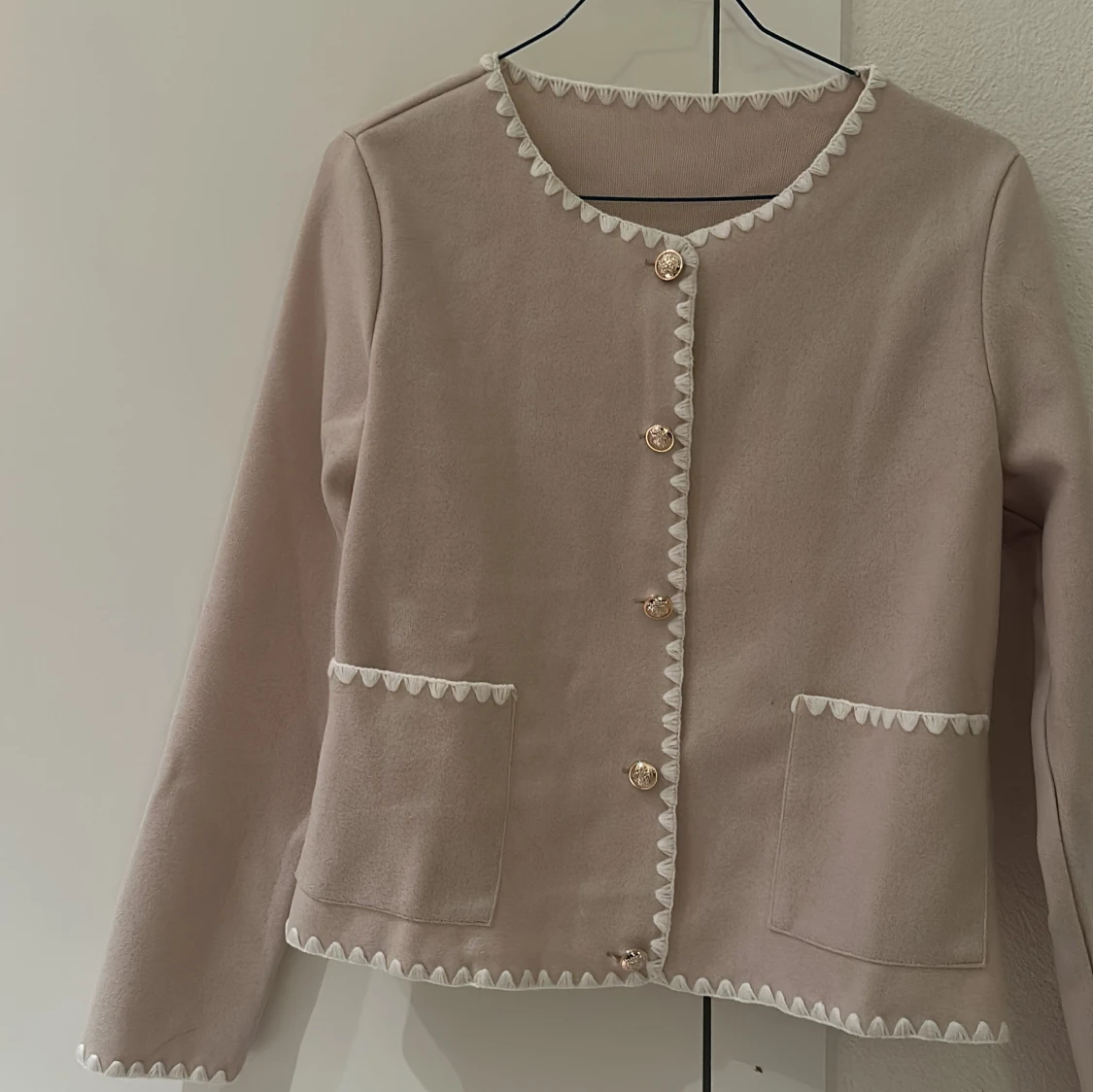 Beige kofta med dekorativa knappar