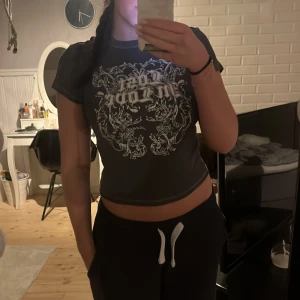 Svart croppad t-shirt med tryck - Grå t-shirt med ett stort vitt tryck på framsidan. Använder inte längre.