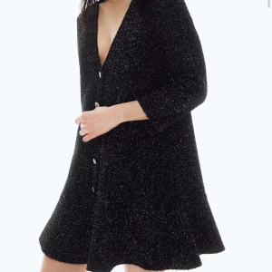 Svart glittrig klänning med knappar - Elegant svart klänning med glittrigt material och knappar framtill. Den har trekvartsärmar och en v-ringad design som ger en stilren look. Perfekt för festliga tillfällen. Helt ny med prislapp kvar & helt slutsåld💖