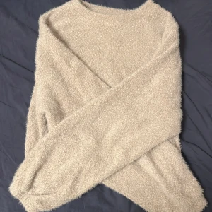 Beige fluffig tröja från Gina Tricot - Mysig beige tröja från Gina Tricot i storlek S. Tröjan är fluffig och har en rund halsringning med långa ärmar. Lite tajtare där nere, använd ett fåtal antal gånget 