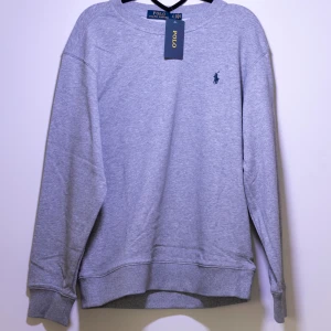Polo Ralph Lauren Sweatshirt - Helt ny Ralph Lauren sweatshirt med det klassiska logotypbroderiet på bröstet. Tröjan har långa ärmar och en rund halsringning. Perfekt för en avslappnad och snygg look. Fler storlekar finns i min profil.😊