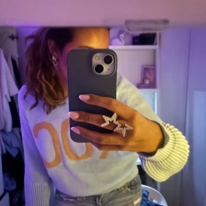 Ljusblå tröja med text - Säljer en ljusblå tröja med orange text på framsidan. Tröjan har långa ärmar och ribbade muddar vid ärmslut och nederkant. Perfekt för Sthlmstil! Helt ny 