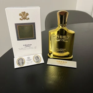 Creed Millesime Imperial Eau de Parfum - Lyxig parfym från Creed i en elegant guldflaska. Millesime Imperial är känd för sin fräscha och marina doftprofil. Flaskan har en kunglig emblem på korken och kommer i en stilren vit förpackning. Perfekt för den som söker en exklusiv doftupplevelse.