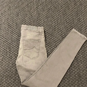Grå jeans från Jacob Cohen - Snygga grå jeansbyxor från jacob cohen i en slim passform. Byxorna har en klassisk femficksdesign och är tillverkade i ett mjukt och stretchigt material för extra komfort. Perfekta för en stilren look. Nyskick.