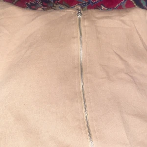 Beige hoodie med dragkedja - Säljer en beige hoodie med dragkedja och huva. Den har snörning vid huvan och är perfekt för en avslappnad stil. Passar bra till både jeans och joggers.