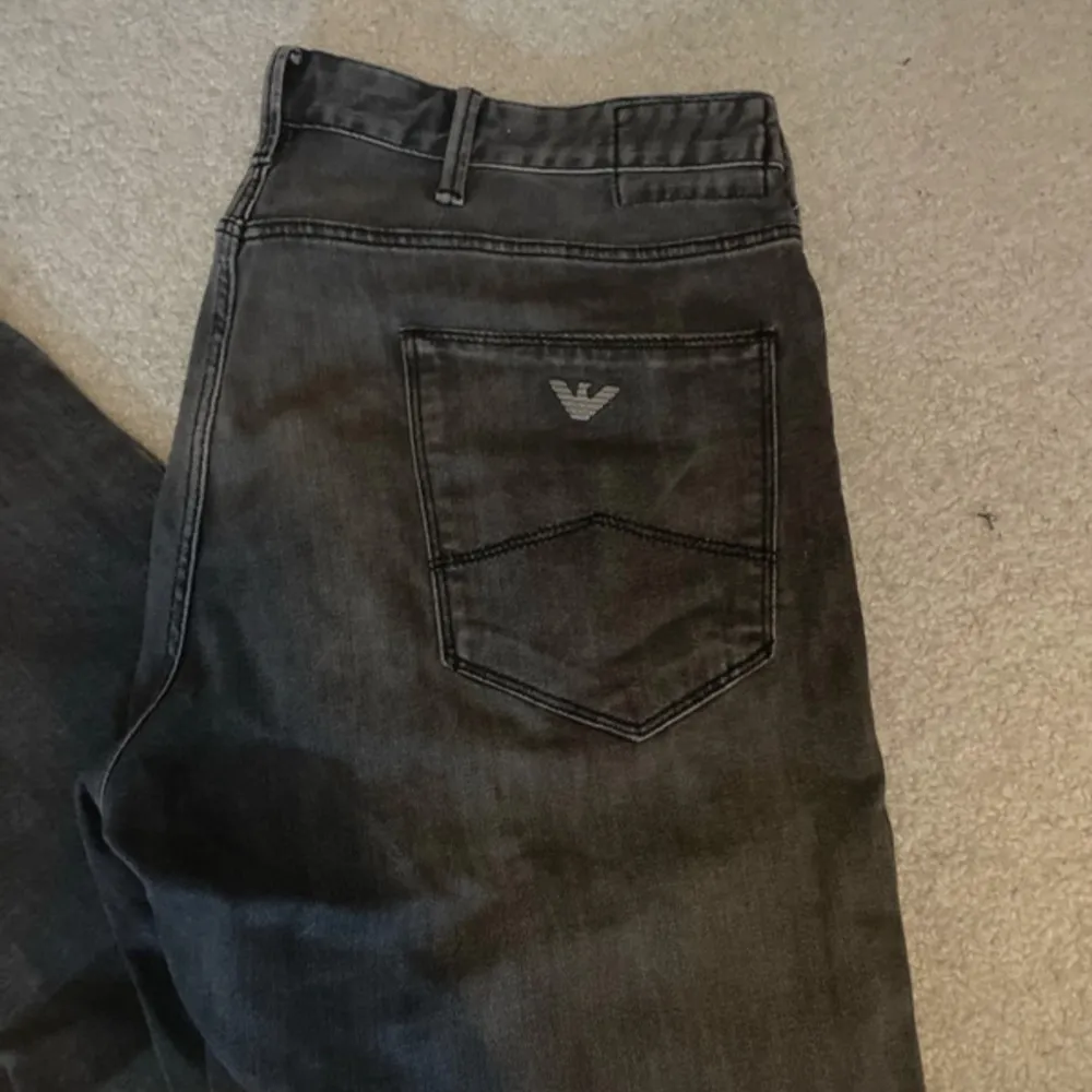 Snygga grå jeans från Armani med klassisk femficksdesign och logga på bakfickan. Perfekta för en stilren look. Priset är diskuterbart . Farkut & Housut.