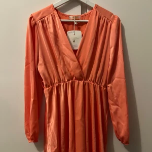 Sommarklänning - Säljer en vacker persikofärgad klämning med långa ärmar. Ny med prislapp