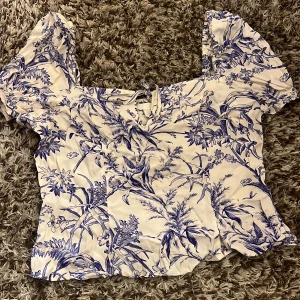 Söt sommar topp  - Blå-vit blommig sommar topp från hm. Jättegullig rosett på framsidan 