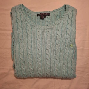 Ljusblå stickad tröja från Ralph Lauren - Säljer en stilren ljusblå stickad tröja från lauren Ralph Lauren med kabelstickat mönster. Tröjan har en broderad logotyp på bröstet och är tillverkad i 100% bomull. Inga tecken på andvändning mycket bra skick ställ gärna frågor om ni undrar något 